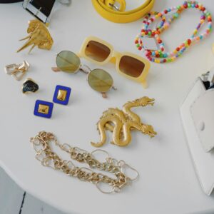 Vibrant flat lay of various colorful accessories including sunglasses, jewelry, and belts.